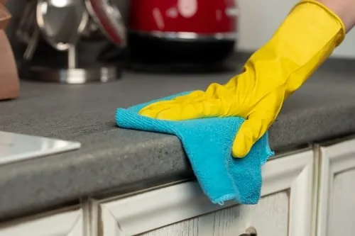 Cleaning a kitchen counter during a house clean